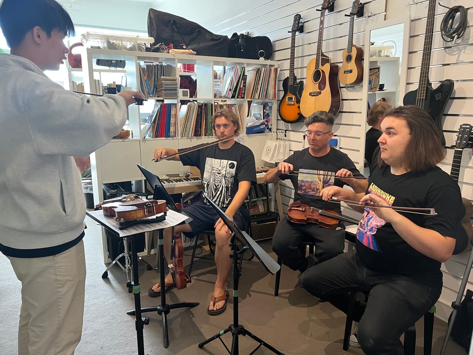 A group of adults being taught violin together in the Music Eternal studio